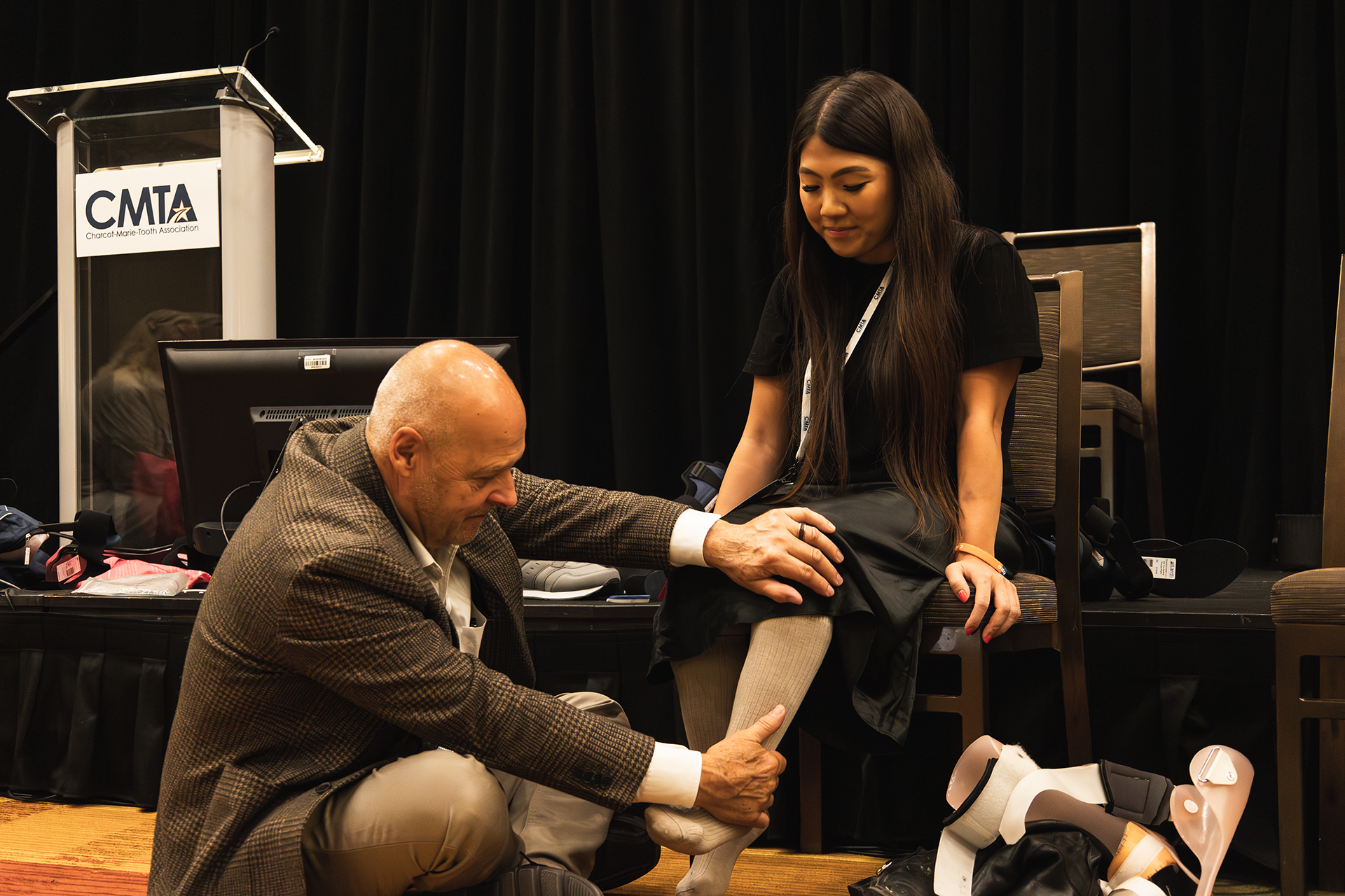 Ken Cornell kneeling holding woman's socked foot